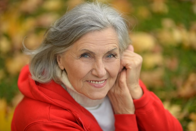 Heureuse belle femme senior dans le parc en automne