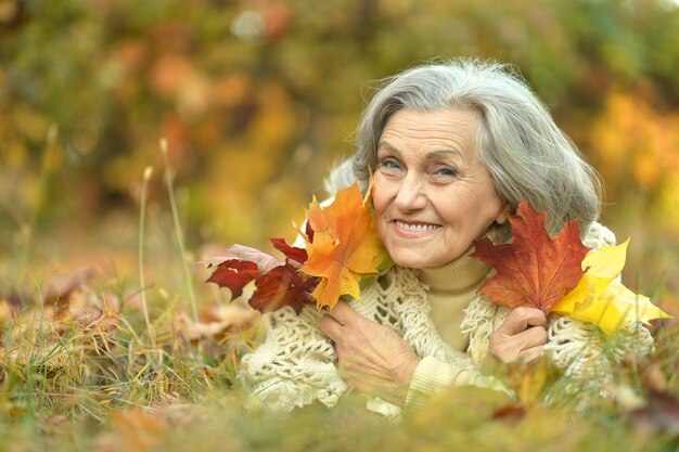 Heureuse belle femme senior dans le parc en automne