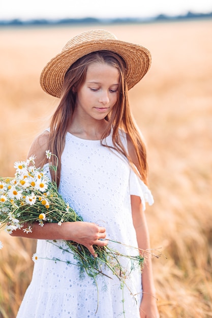 Heureuse belle fille dans un champ de blé à l'extérieur