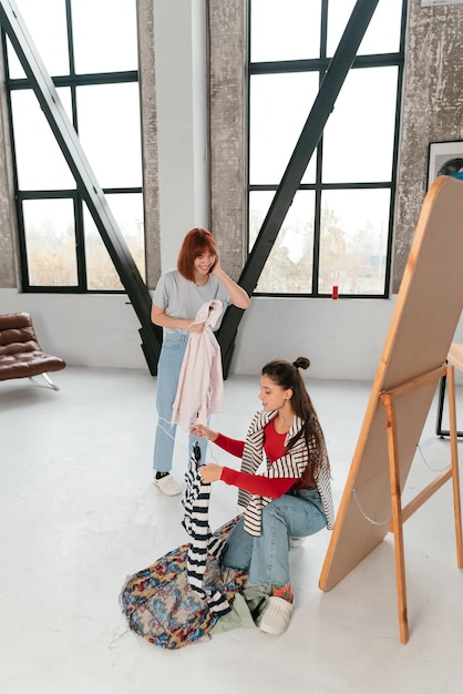 Heureuse belle jeune femme choisissant des vêtements avec sa petite amie