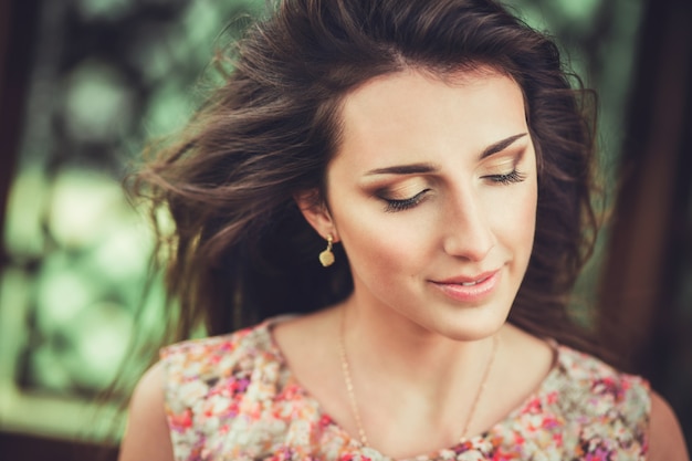 Heureuse belle jeune femme dans le parc de fleurs de printemps.