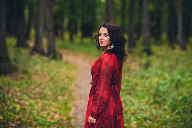 Heureuse belle jeune femme danse de la liberté dans le parc d'été avec des arbres en arrière-plan. Parc du Palais d'été.