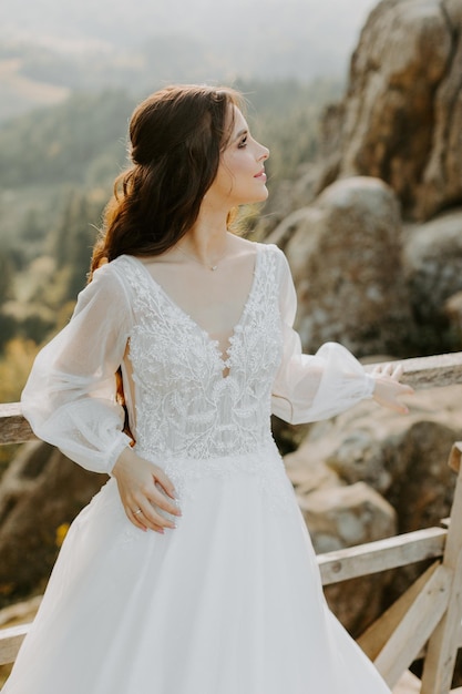 Heureuse belle jeune mariée à l'extérieur sur une prairie d'été au coucher du soleil