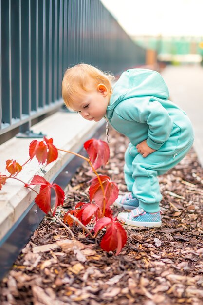 Heureuse belle petite fille en bonne santé dans l'ensemble bleu s'amusant dans l'enfant actif de la ville par temps froid à l'extérieur