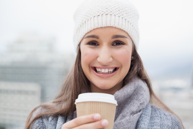 Heureuse brune avec des vêtements d&#39;hiver sur la tenue de la tasse de café