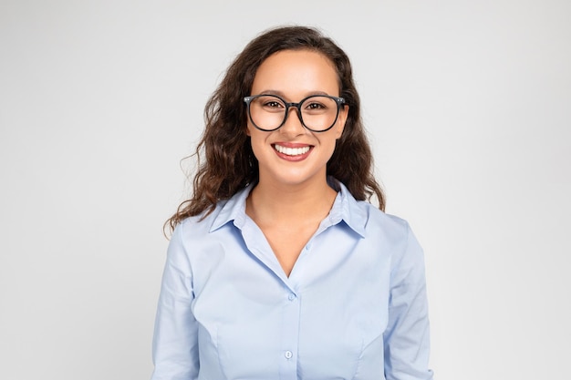 Heureuse, confiante, calme, millénaire, femme d'affaires caucasienne, enseignante en tenue de soirée et lunettes