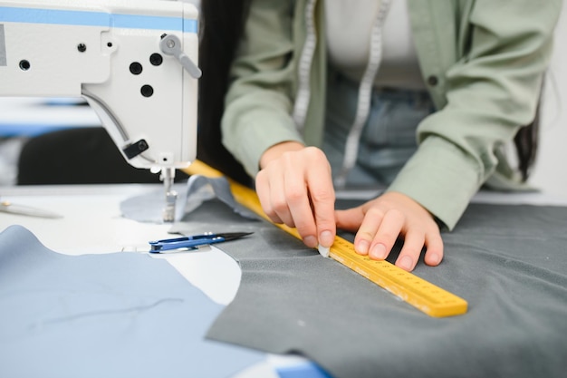 Heureuse couturière travaillant avec une machine à coudre dans une usine textile