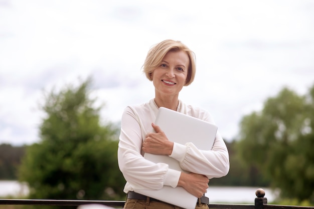 Heureuse dame élégante avec un ordinateur portable à l'avenir