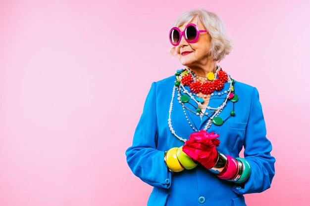 Heureuse et drôle vieille dame cool avec des vêtements à la mode portrait sur fond coloré Jeune grand-mère avec des concepts de style extravagants sur l'ancienneté de style de vie et les personnes âgées