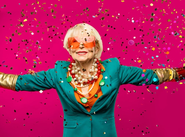 Photo heureuse et drôle vieille dame cool avec des vêtements à la mode portrait sur fond coloré jeune grand-mère avec des concepts de style extravagants sur l'ancienneté de style de vie et les personnes âgées