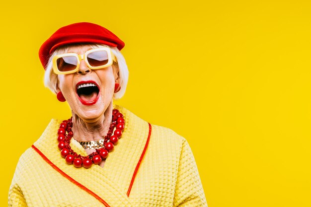 Photo heureuse et drôle vieille dame cool avec des vêtements à la mode portrait sur fond coloré jeune grand-mère avec des concepts de style extravagants sur l'ancienneté de style de vie et les personnes âgées
