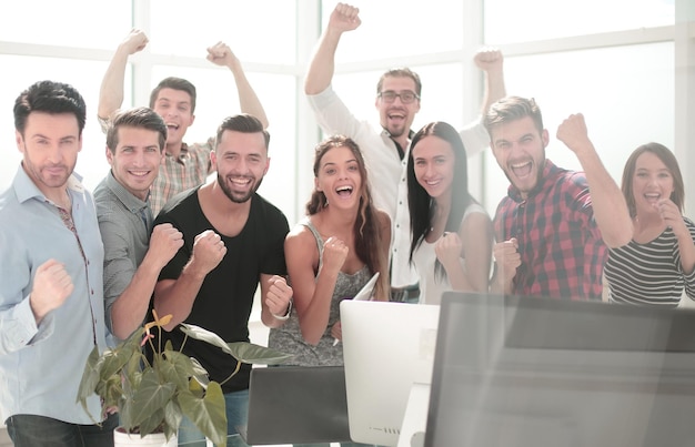 Heureuse équipe commerciale debout dans un bureau moderne