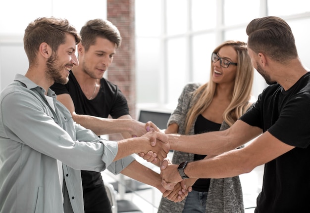 Heureuse équipe commerciale souriante debout dans une rangée au bureau