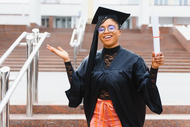 Heureuse étudiante afro-américaine avec diplôme à l'obtention du diplôme