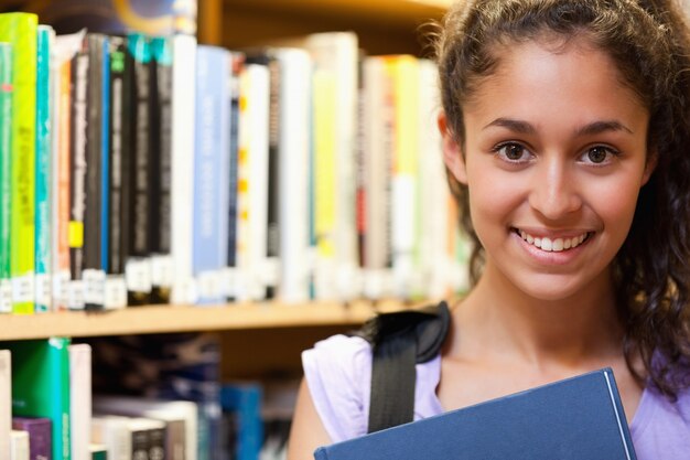 Heureuse étudiante tenant un livre