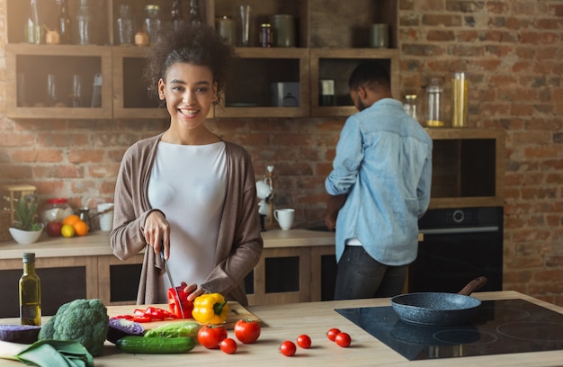 Heureuse famille afro-américaine à la cuisine. Couple noir cuisinant à l'intérieur du loft