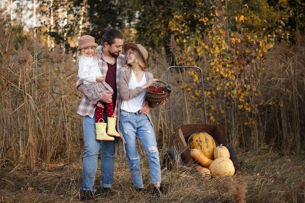 Heureuse famille d'agriculteurs avec récolte de citrouilles en automne