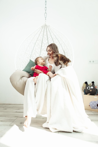 Heureuse famille aimante Mère et petite fille dans le salon Jolie maman et joli bébé s'amusent et jouent avec une marionnette hibou