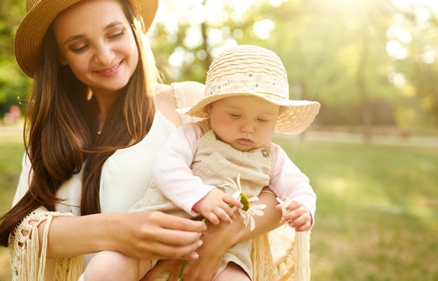 Heureuse famille élégante et aimante. mère jouant avec son bébé en plein air. joli bébé sourit et aime. Concept de la fête des mères.