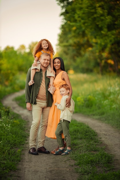 Heureuse famille internationale lors d'une promenade d'été dans le parc.