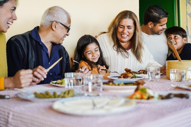 Photo heureuse famille latine s'amusant à manger ensemble à la maison se concentrer sur le visage de grand-mère