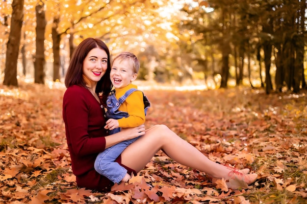 Heureuse famille maman et bébé garçon jouent à l'extérieur dans la nature dans le parc d'automne Un petit garçon et sa mère dans le parc d'automne Animations d'automne pour les enfants