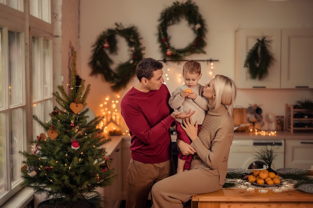 Heureuse famille maman papa fils se prépare pour la nouvelle année à la maison dans la cuisine.