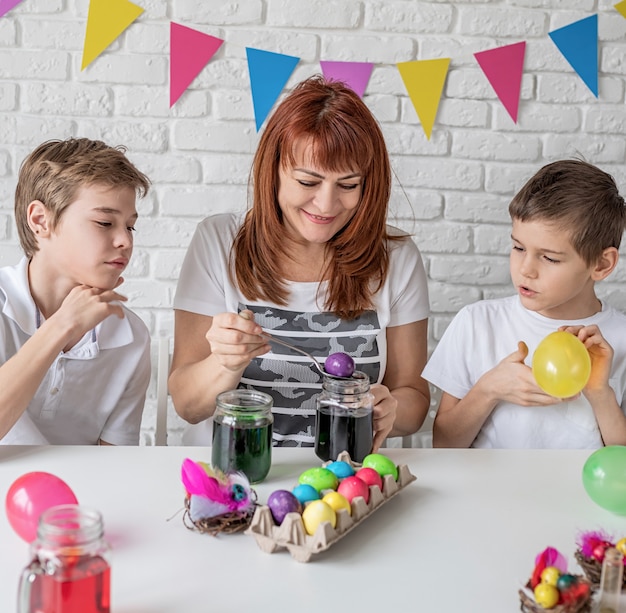 Heureuse Famille De Mère Et Deux Garçons Faisant Sauter Les Ballons