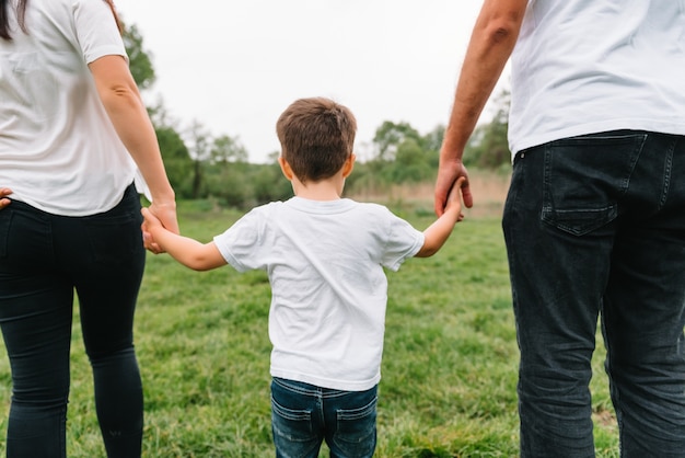 Heureuse famille mère père et fils enfant sur la nature au coucher du soleil.