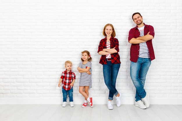 Heureuse famille mère père fils fille sur un mur blanc vierge