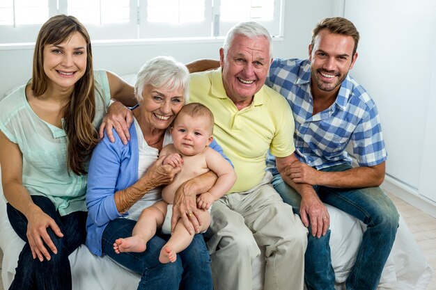 Heureuse famille multi-générations sur lit à la maison