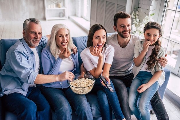 L'heureuse famille multigénérationnelle devant la télévision