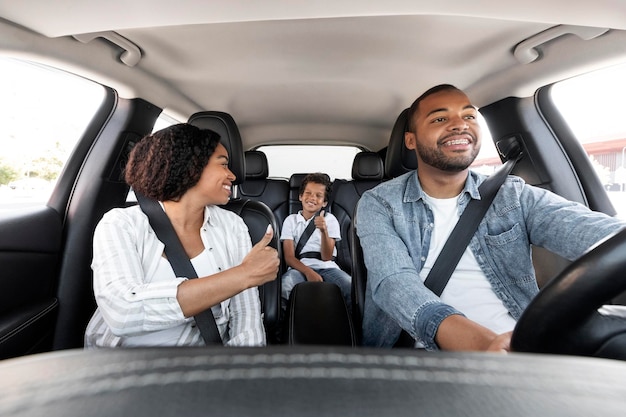 Photo heureuse famille noire profitant d'un trajet en voiture ensemble