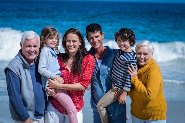 Heureuse famille posant à la plage