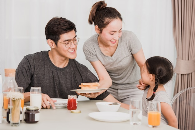 Heureuse famille prenant son petit déjeuner à la maison