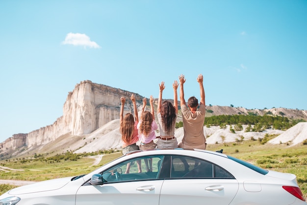 Heureuse famille de quatre personnes marchant dans les montagnes