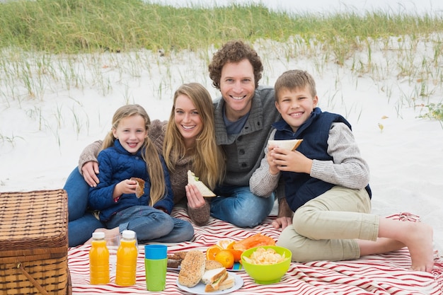 Heureuse famille de quatre personnes à un pique-nique de plage