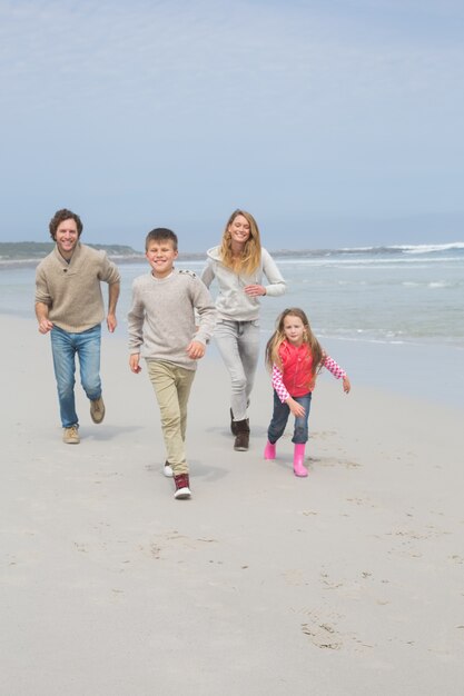 Heureuse famille de quatre personnes à la plage