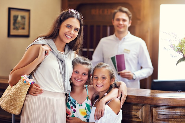 Heureuse famille s'enregistrant à l'hôtel à la réception