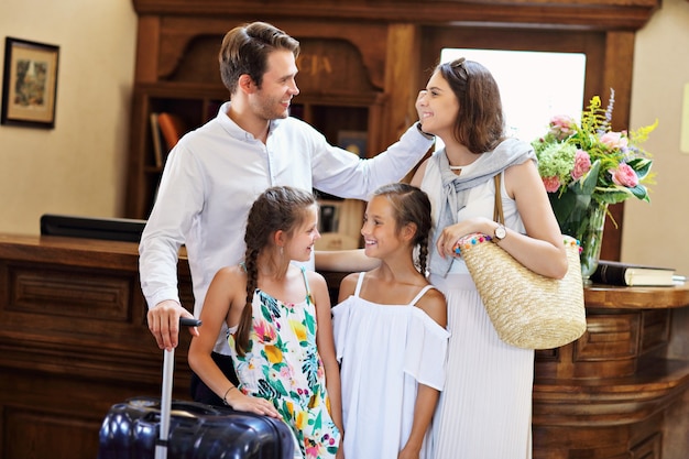 Heureuse famille s'enregistrant à l'hôtel à la réception