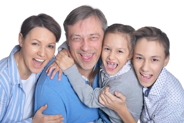 Heureuse famille souriante de quatre personnes posant sur fond blanc