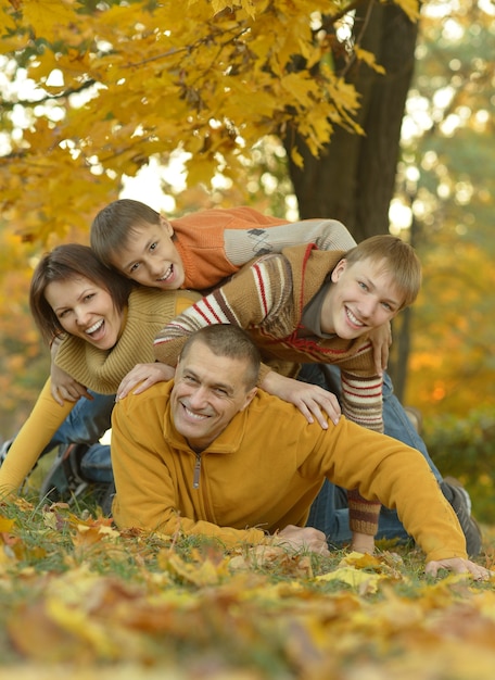 Heureuse famille souriante relaxante dans la forêt d'automne
