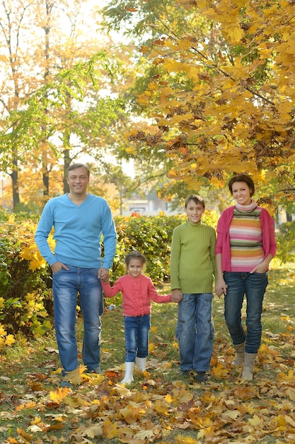 Heureuse famille souriante relaxante dans la forêt d'automne