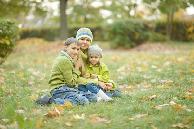 Heureuse famille souriante relaxante dans le parc en automne