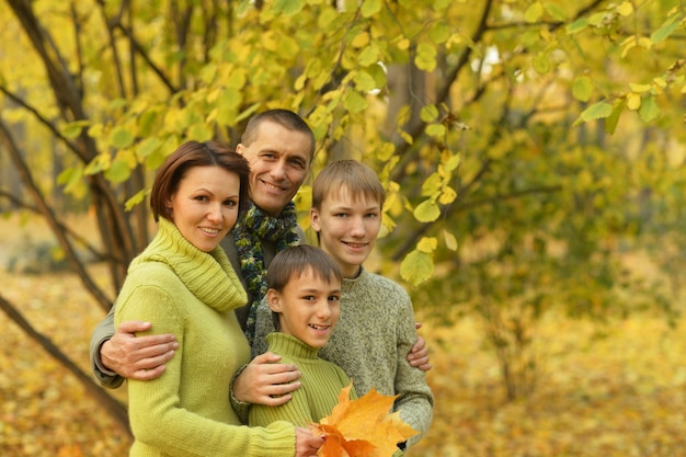 Heureuse famille souriante relaxante dans le parc en automne