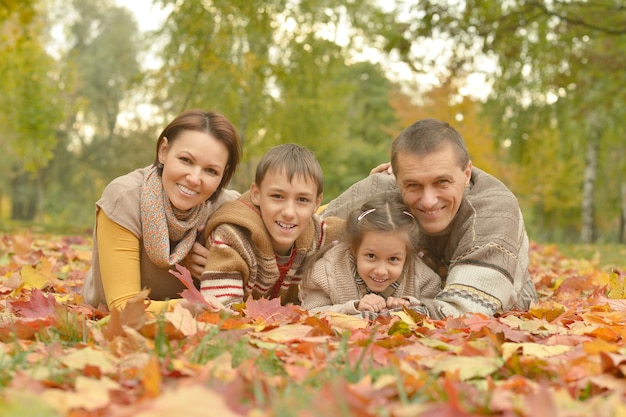 Heureuse famille souriante relaxante dans le parc en automne