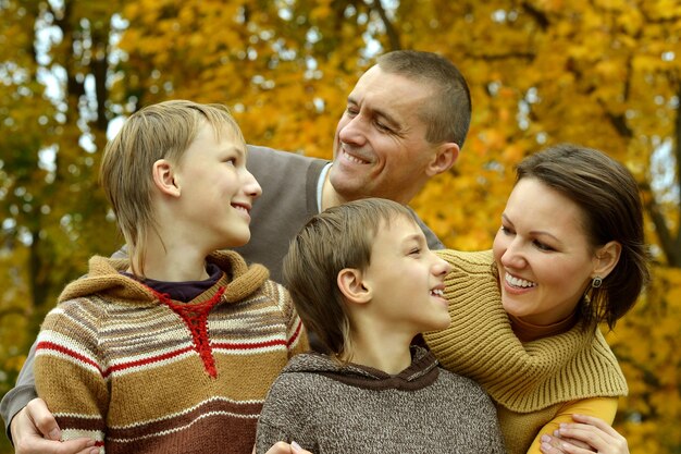 Heureuse famille souriante relaxante dans le parc en automne