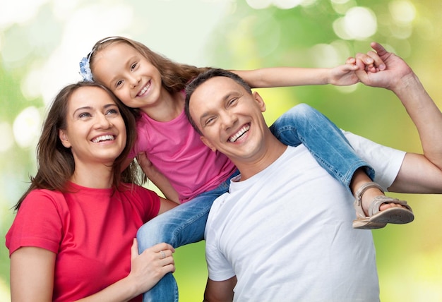 Heureuse famille souriante avec sa fille sur fond de parc