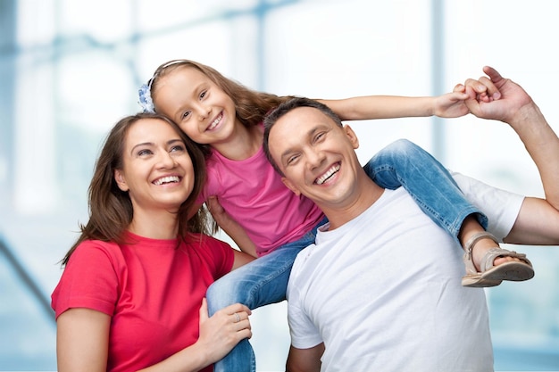 Heureuse famille souriante avec sa fille sur fond