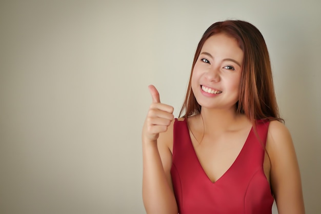 Heureuse femme acceptant réussie positive montrant le geste du pouce vers le haut, modèle féminin asiatique